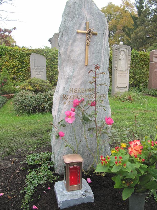 Grabmal aus Atlantisfelsen mit Bronzekreuz und Rosen, gefertigt vom Steinmetzbetrieb Fritz Reuter
